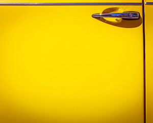 vivid yellow car door and chrome handle, space for your text
