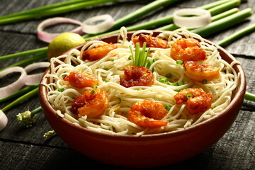 Bowl of tasty seafood noodles with fresh prawns . Asian recipes. 