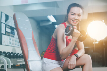 Healthy Asian girl Wear exercise clothes, use exercise equipment in the gym.
