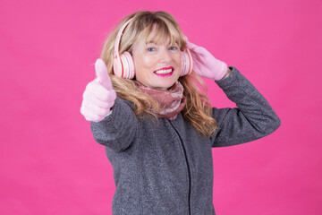 warm woman with gloves and scarf listening to music with headphones