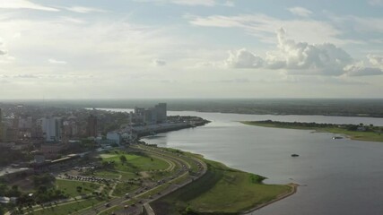 Aerial view Asuncion river Paraguay. Cityscape with downtown on the river, the shoreline on which there are houses and the road on which cars drive.