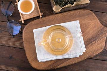 A pot of green tea on a cutting board