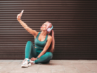 Fitness smiling woman in green sports clothing with pink hair.Young beautiful model with perfect...