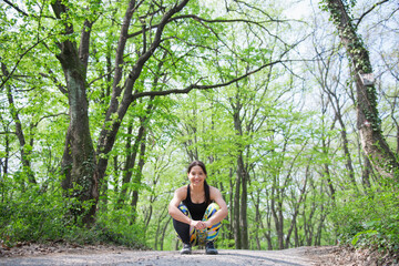 Relaxed and cheerful female athlete enjoying her training during the spring morning in the woods