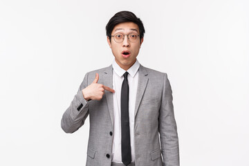 Waist-up portrait of surprised and confused asian businessman, office worker pointing at himself...