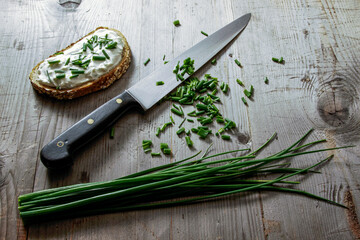 Kitchen knife with sliced leek on wooden background