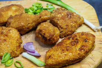Fried chicken schnitzel on a cutting board. Homemade breaded schnitzel. Fried crispy chicken legs.