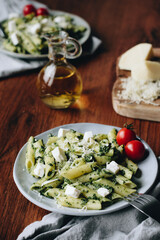 pasta with spinach and feta cheese. Olive oil. Pasta on a wood table. Pasta with pesto