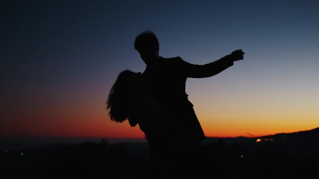 Silhouette di una coppia al tramonto che balla per san Valentino