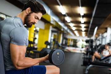 Fototapeta premium Portrait of fit man working out in gym. Sport people healthy lifestyle exercise concept