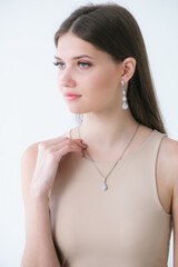 Trending silver jewelry set on a beautiful young girl with long dark hair. Beauty and fashion 