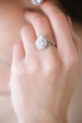 Trendy silver ring on a beautiful young girl in a white fashionable jacket. Beauty and fashion 
