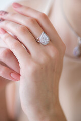 Trendy silver ring on a beautiful young girl in a white fashionable jacket. Beauty and fashion 
