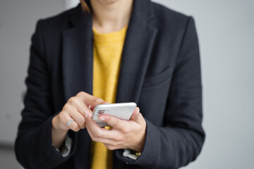 ビジネス素材　スマホを打っている女性
