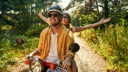 Happy young caucasian couple driving scooter