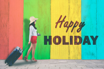 Young woman walking with happy holiday text