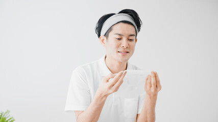 フェイスパックをつける若い男性　ビューティーイメージ