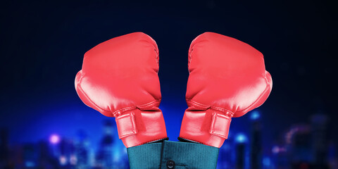 Businesswoman hand wearing two boxing gloves