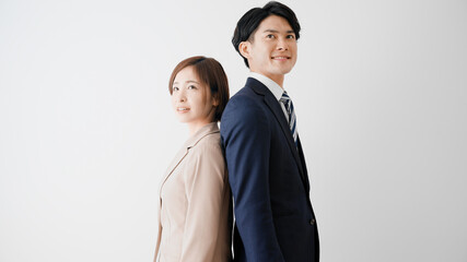 背中合わせで立つビジネスマンとビジネスウーマン