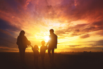 Silhouette of Muslim family walking toward city