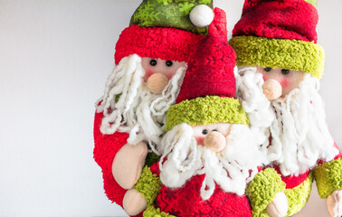 Closeup of three Santa Claus dolls.