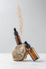 Aesthetic minimalist beauty care therapy concept. Organic serum oil cosmetics bottles on stone with...