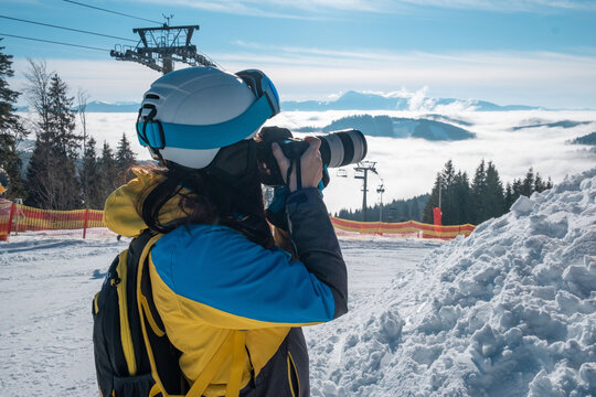 woman skier taking picture of mountains