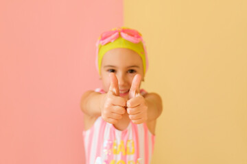 Cheerful positive girl swimmer showing success gesture, thumb up with hands, saying well done....