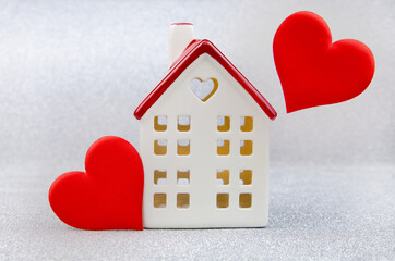 A white house with a red roof and a heart on a silver background.The theme of love and...