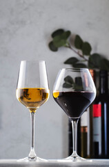 Wines assortment. Red, white, rose wine in glasses and bottles on gray table background. Wine bar, shop, tasting concept