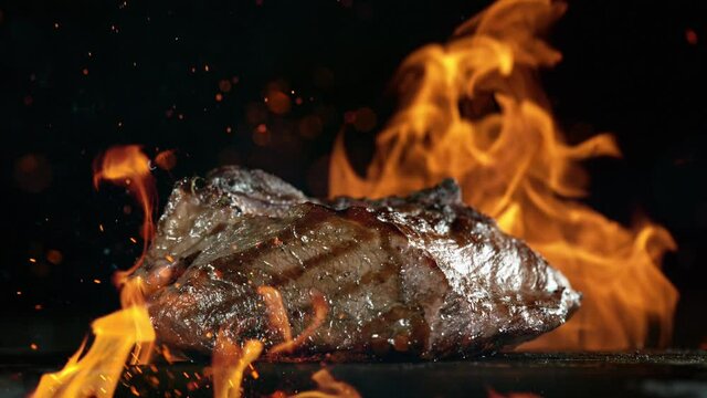 Tasty beef steak on iron cast grate, super slow motion, filmed on high speed cinematic camera at 1000 fps.