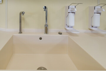elbow soap and antiseptic dispenser or sanitizer wall mounted for hand disinfection and water tap sink with faucet bathroom or clinic