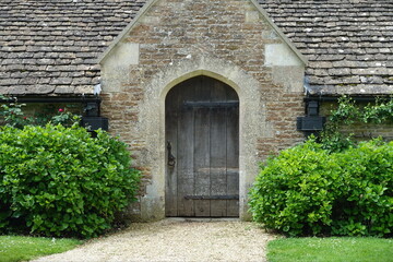 View of an old oak door of a stone cottage house
