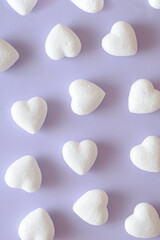 Fototapeta na wymiar White glittery hearts on a purple background. Valentines day aesthetic wallpaper.