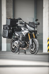 Obraz premium Motorrad auf Parkdeck / Parkhaus mit Koffern fertig für die Reise