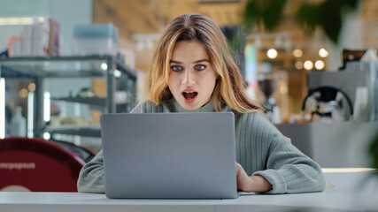 Portrait beautiful young girl student business woman female user winner looking into laptop surprised wide open mouth with delight good news applauds happiness winning opportunity new job notification