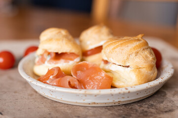 Eclairs with salted red fish and cream cheese on a white plate. Food photography.  An example of...