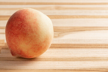 Peach, beautiful and tasty peach positioned on a rustic wooden surface, selective focus.