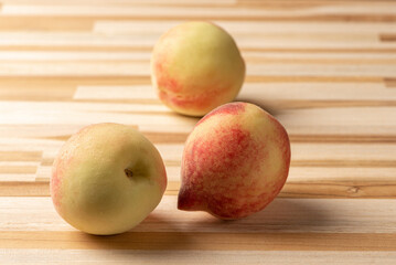 Peaches, beautiful and tasty peaches positioned on a rustic wooden surface, selective focus.