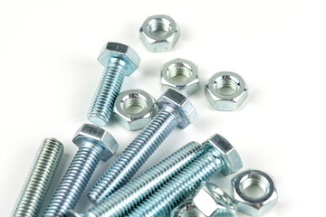 A large group of silver fasteners for fastening structures. Bolts and nuts with washers close-up on a white background.