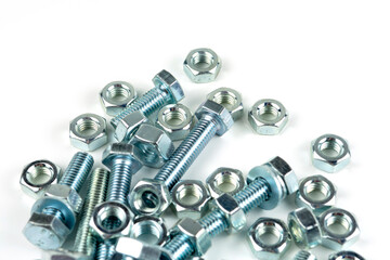 A large group of silver fasteners for fastening structures. Bolts and nuts with washers close-up on a white background.