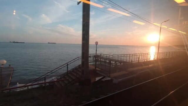 sea at sunset from the window moving trains