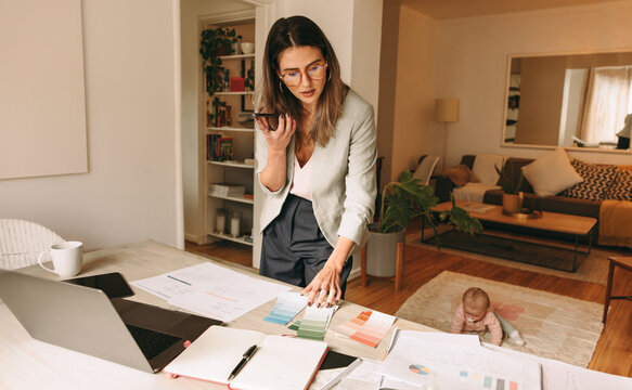Working mom speaking on the phone in her home office