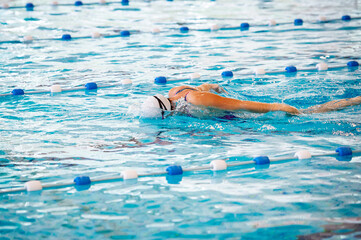 Swimmer swimming butterfly stoke alone in an empty swimming pool