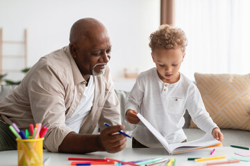African American Little Boy Showing Drawings To Grandpa At Home - obrazy, fototapety, plakaty