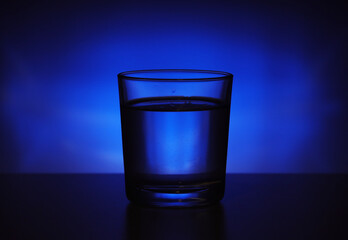 A glass with water at blue background	