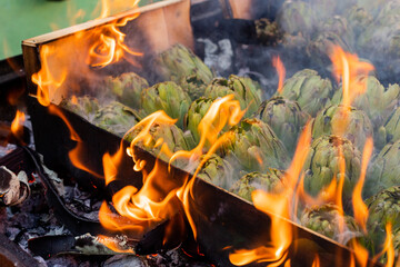 A wooden box of artichokes grilled directly on the fire.