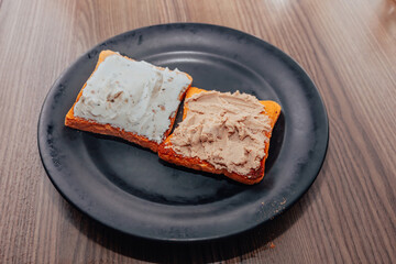 oasted bread on a plate. Bread with pate and melted cheese.