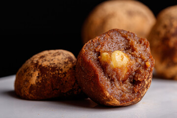 Beautiful candy truffle with a nut inside on a white plate on a black background