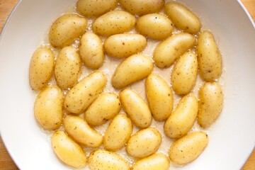 cooking fried potatoes in white pan